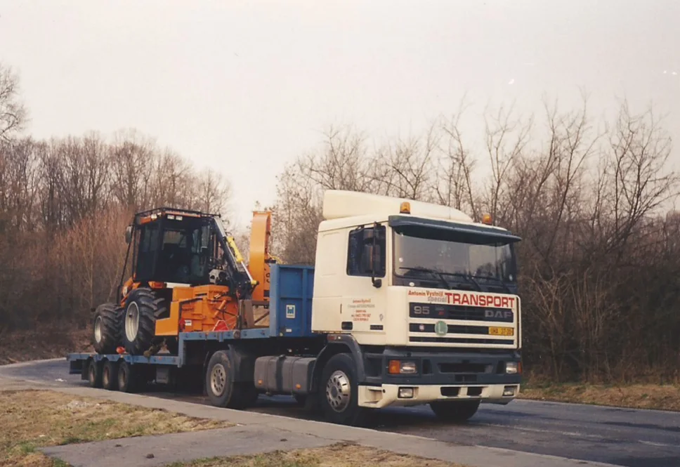 Starší fotografie z archivu firmy: tahač DAF s nápisem Antonín Vystrčil Transport a naloženou technikou